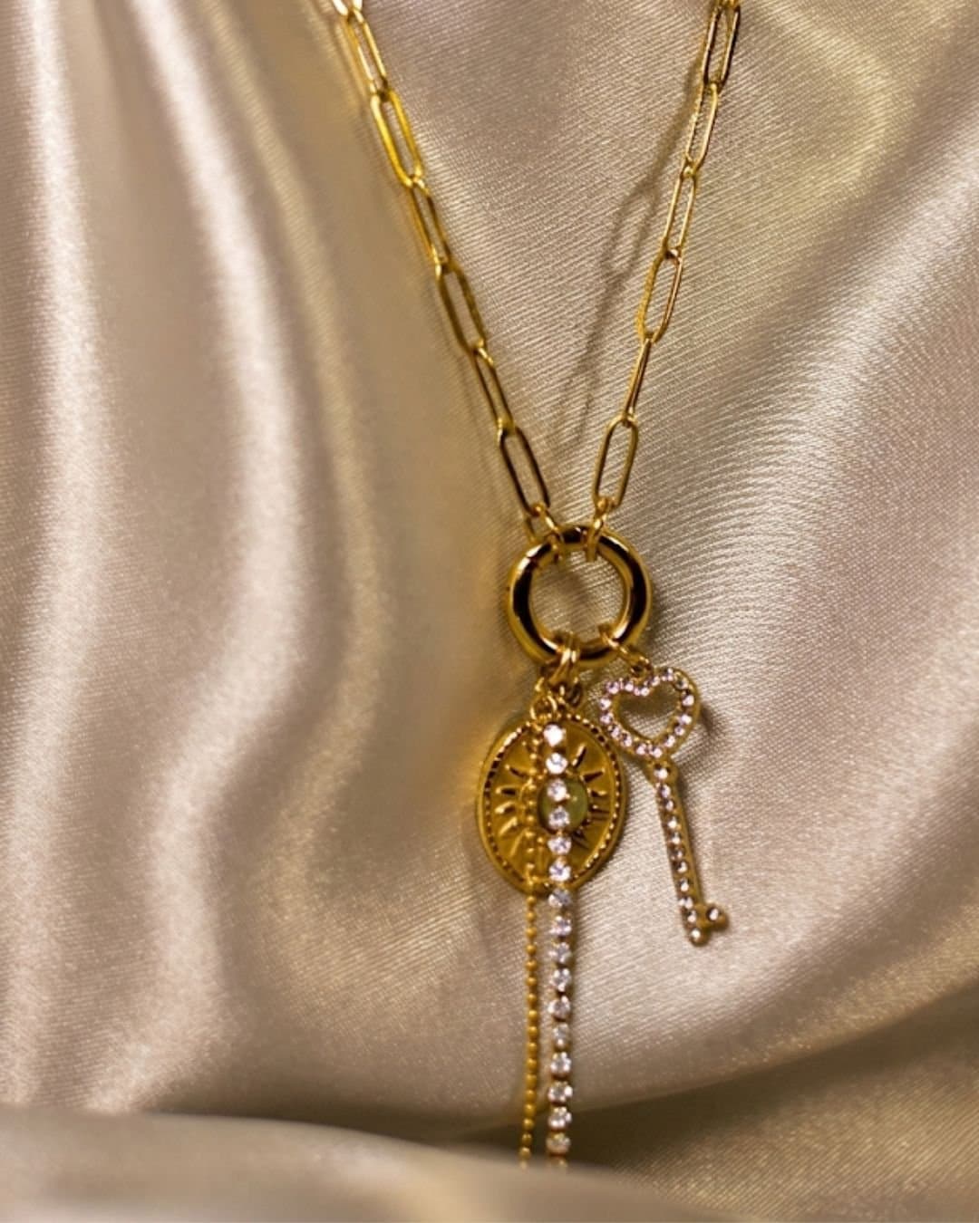 Golden chain necklace with heart key, round sunburst charms